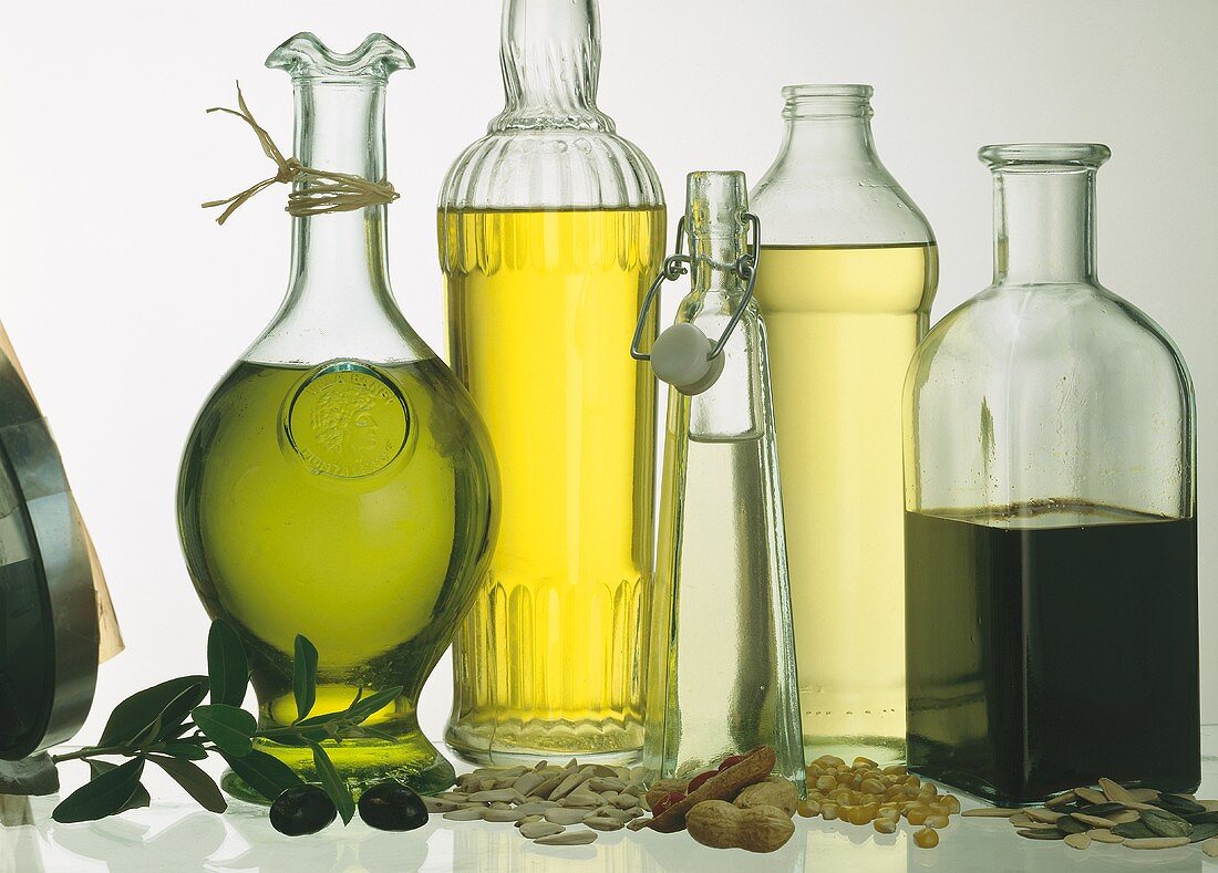 Stillleben mit fünf verschiedenen Ölsorten in Flaschen