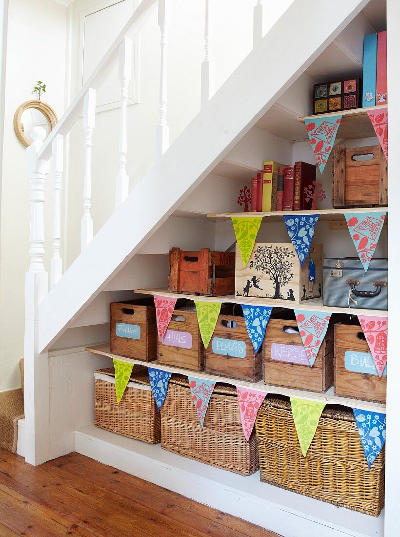 Storage shelves under staircase decorated with bunting