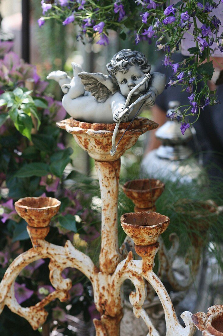 Small cherub on rusty candelabra