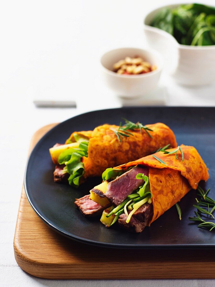 Tomato and pepper wraps with haloumi, roast beef and pine nuts