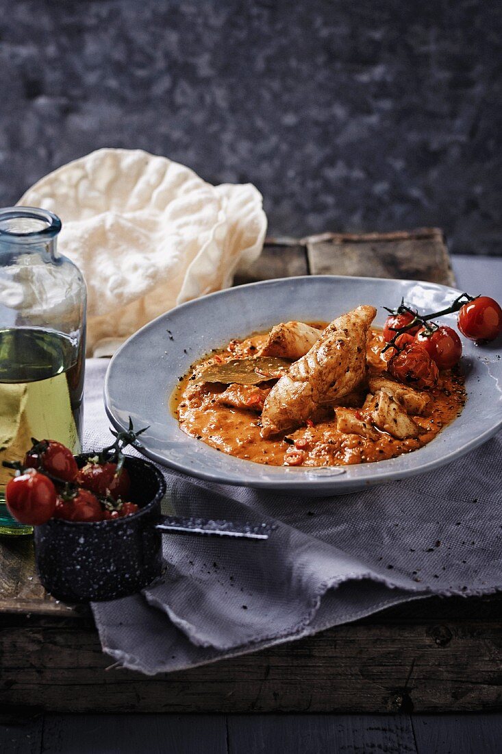 Creamy fish curry with tomatoes and poppadoms