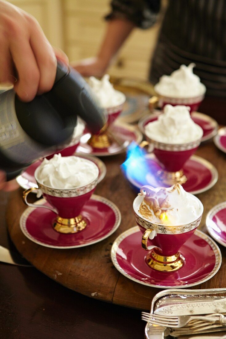 Meringue being browned with a blowtorch