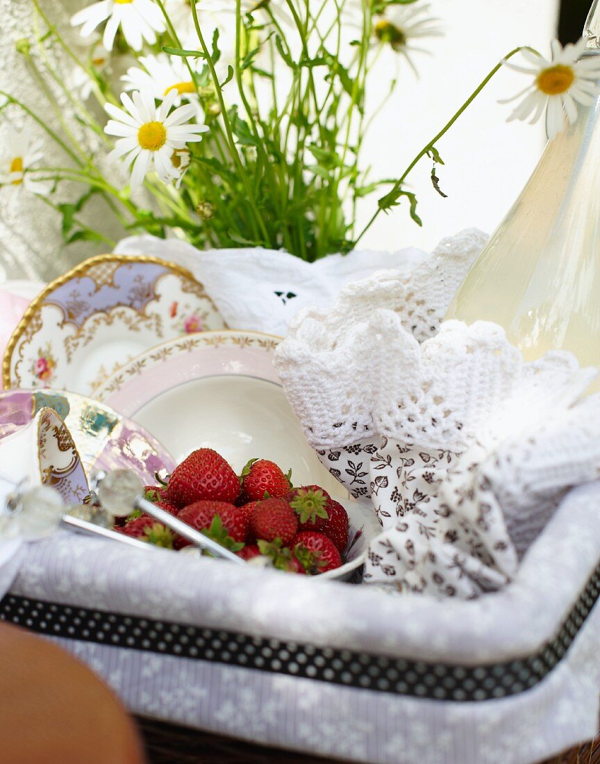 A picnic basket with strawberries and lemongrass lemonade on a bicycle