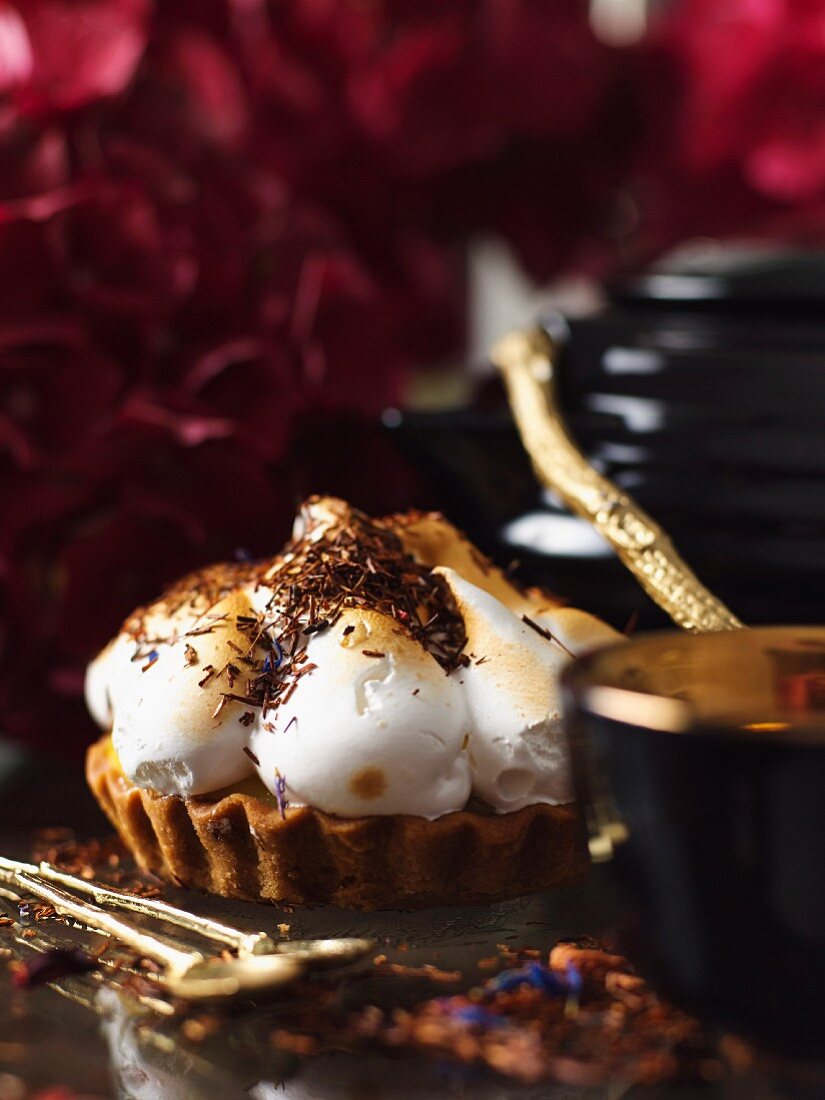 A vanilla tartlet topped with meringue and grated chocolate