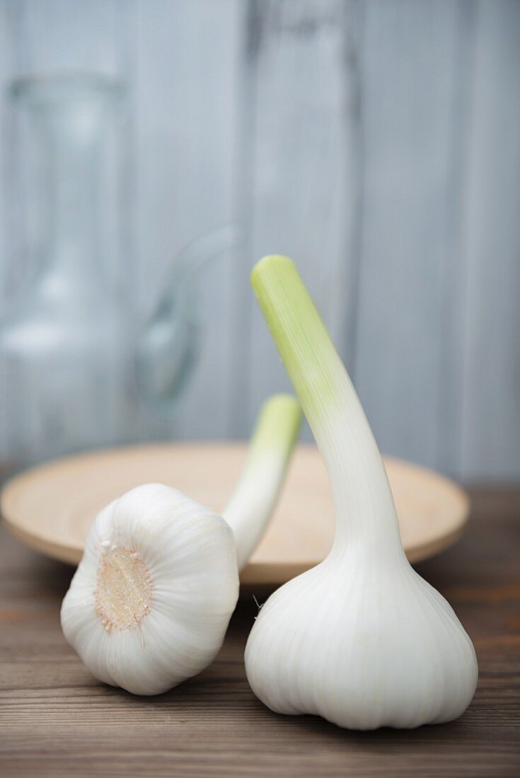 Two fresh garlic bulbs on a wooden table