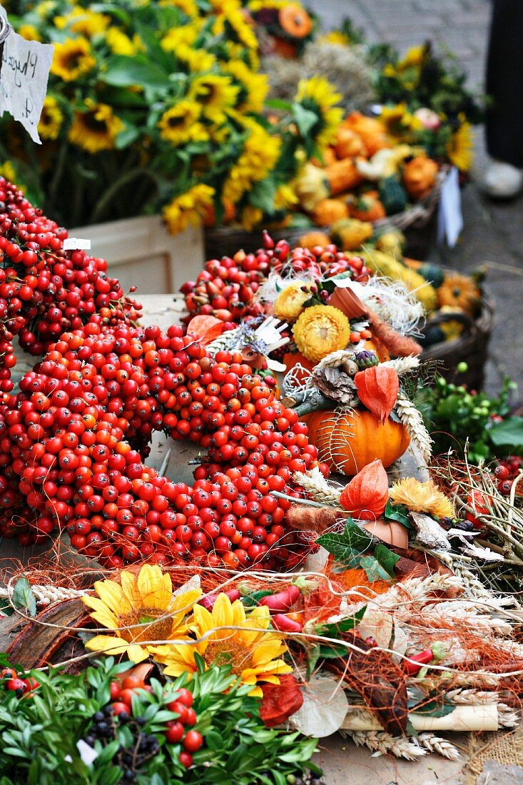 Hagebuttenkränze und natürliche Bastelutensilien auf einem Herbstmarkt