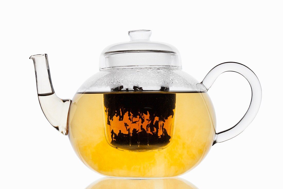 Tee zieht in Glasteekanne mit Filter