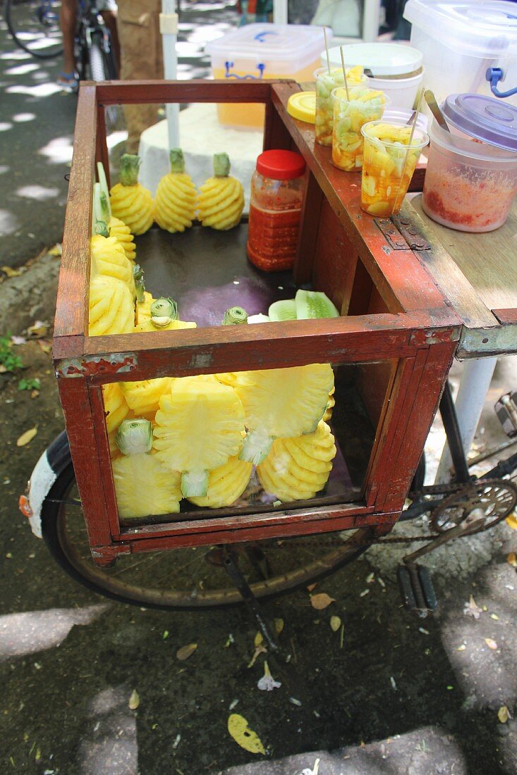Geschälte frische Ananas in Transportbehälter auf Fahrrad (Mauritius)