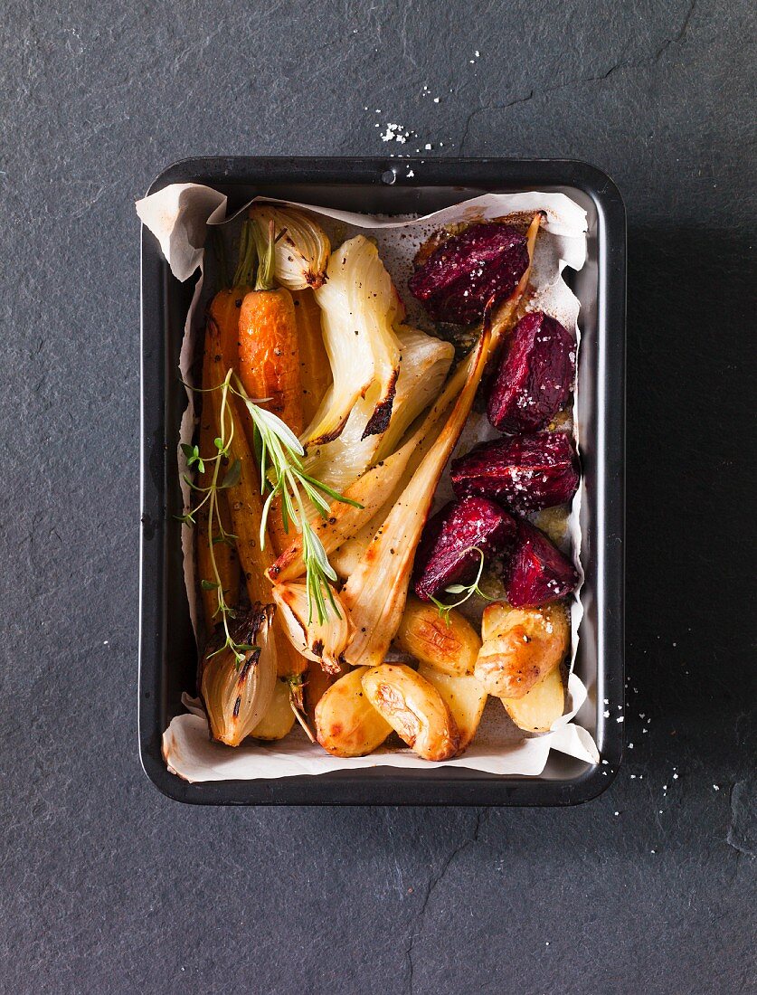 Oven-roasted root vegetables in a roasting tin (seen from above)