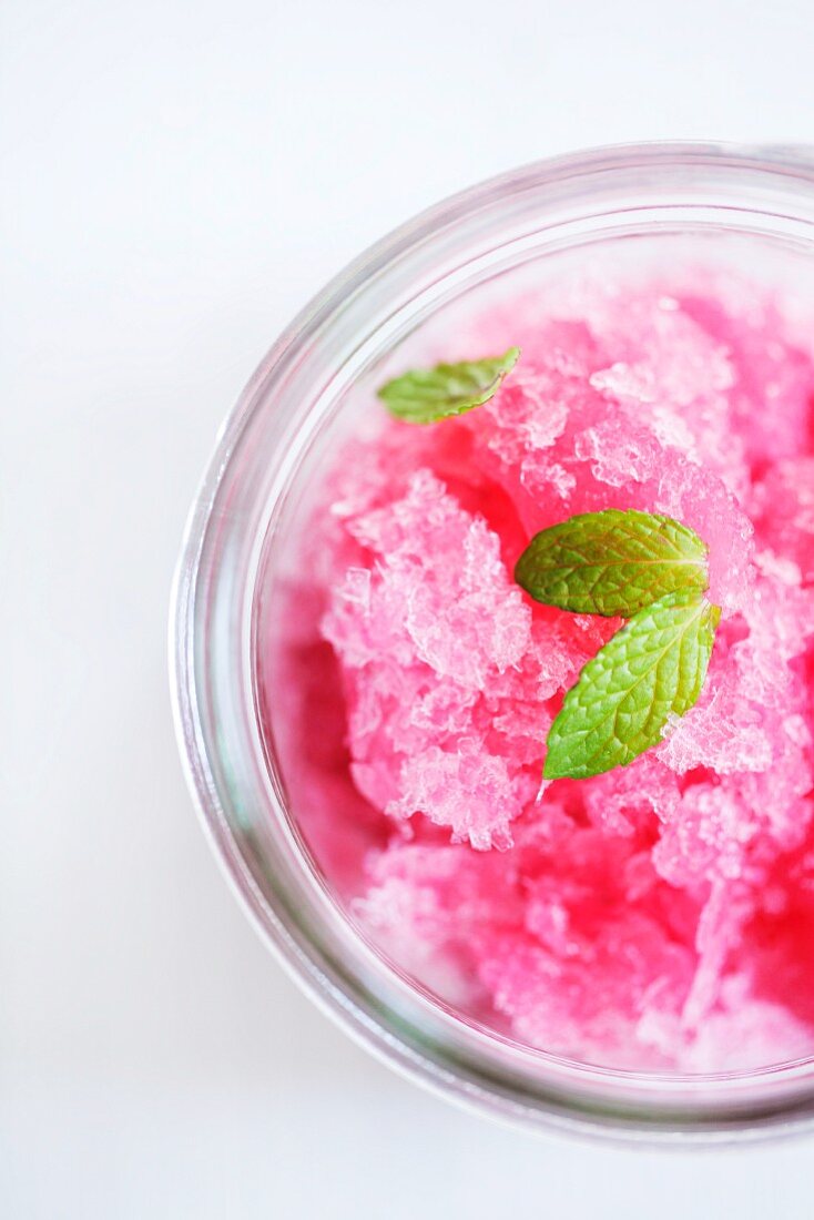 A glass of pomegranate sorbet with mint