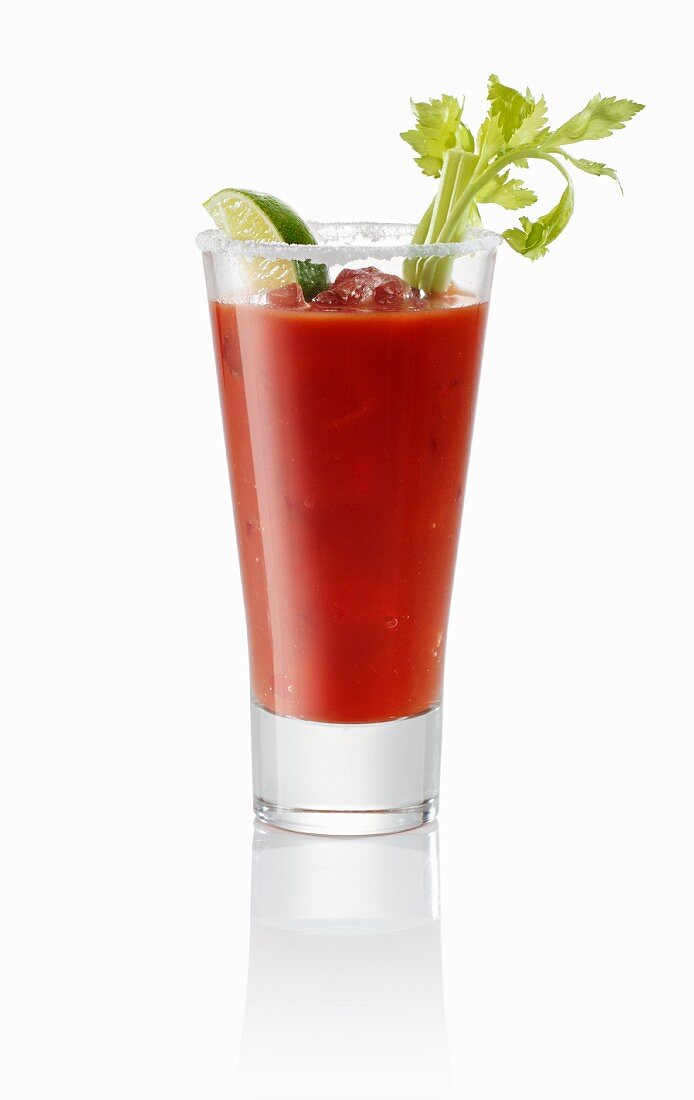A Bloody Mary garnished with a sprig of salary and wedge of lime