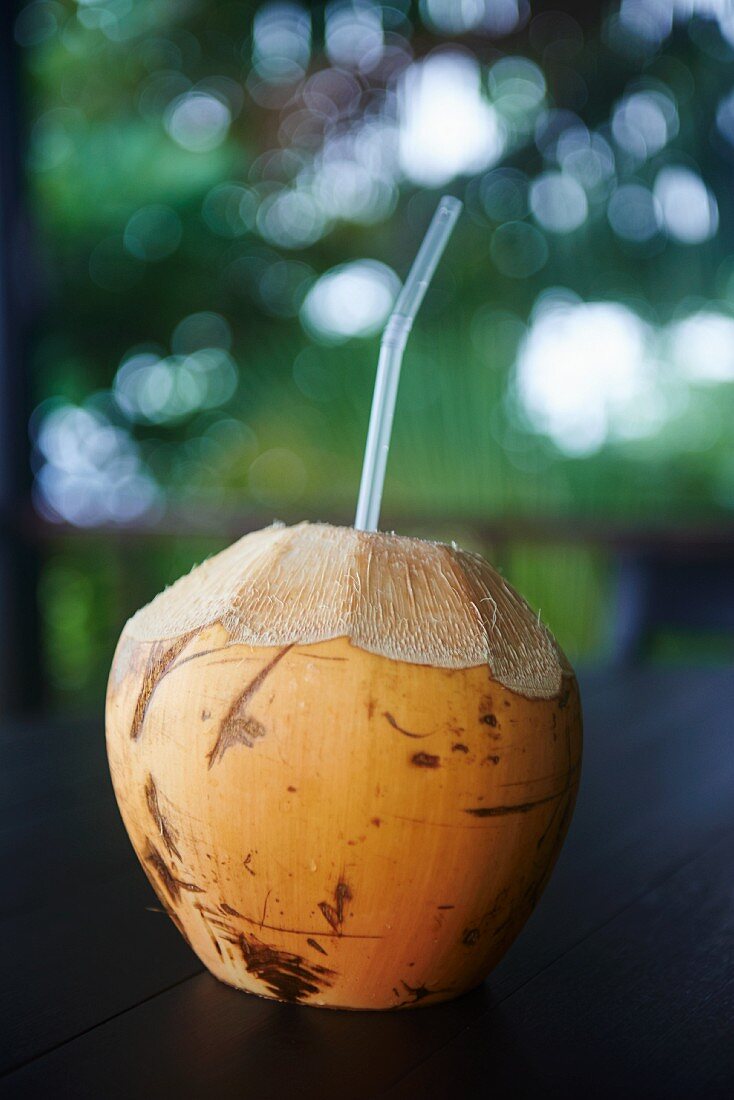 A coconut with a straw