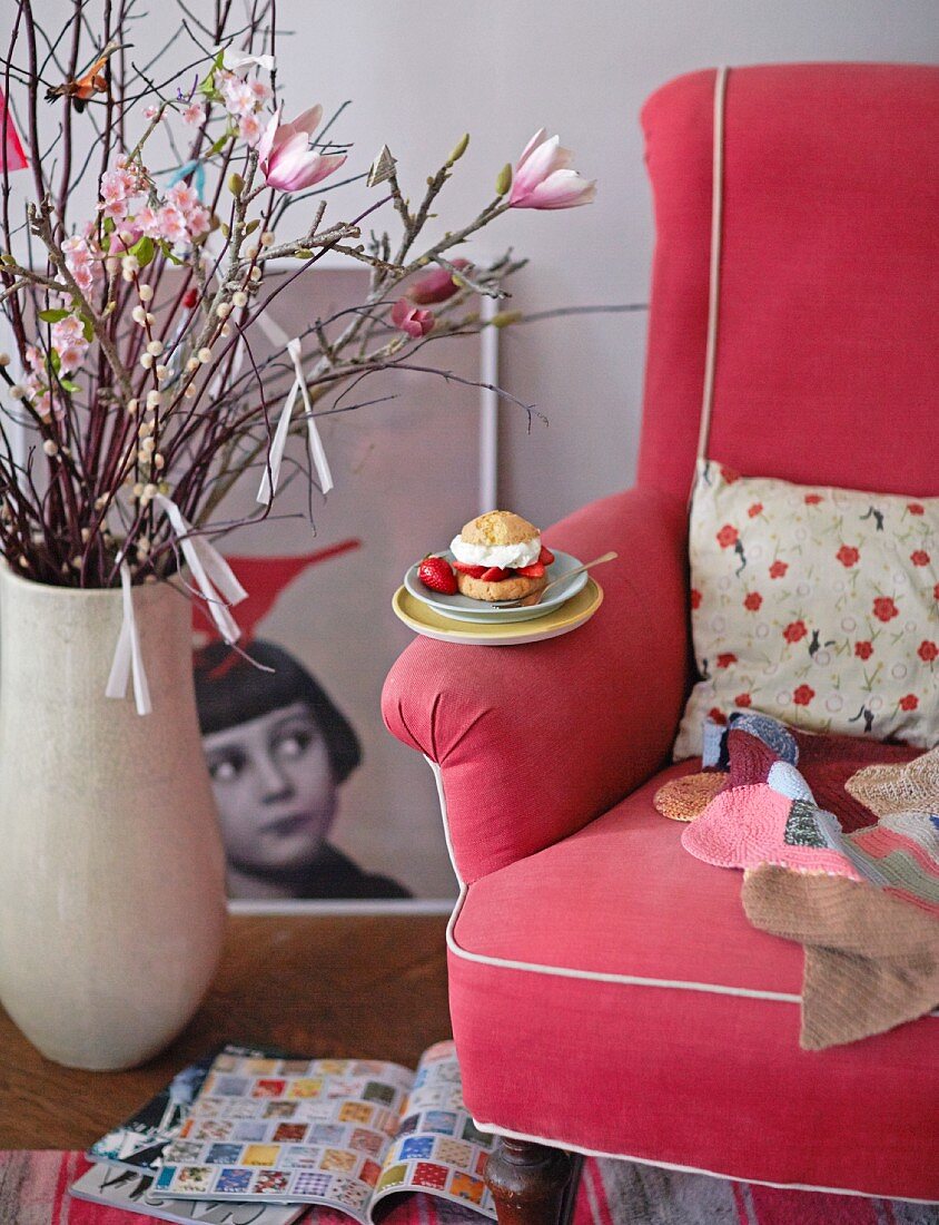 A strawberry and cream cake on the arm of a chair