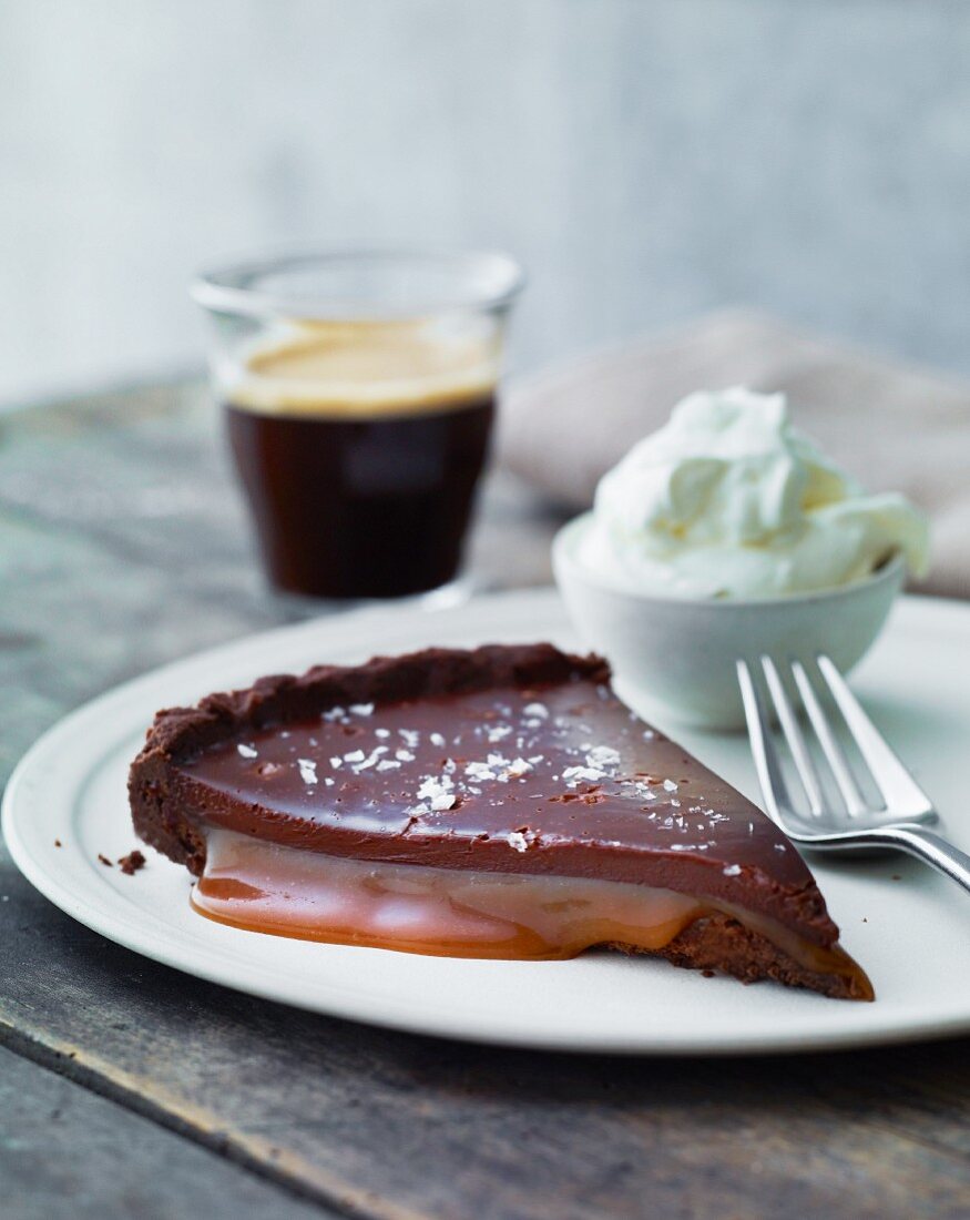 A slice of chocolate cake with caramel sauce and cream