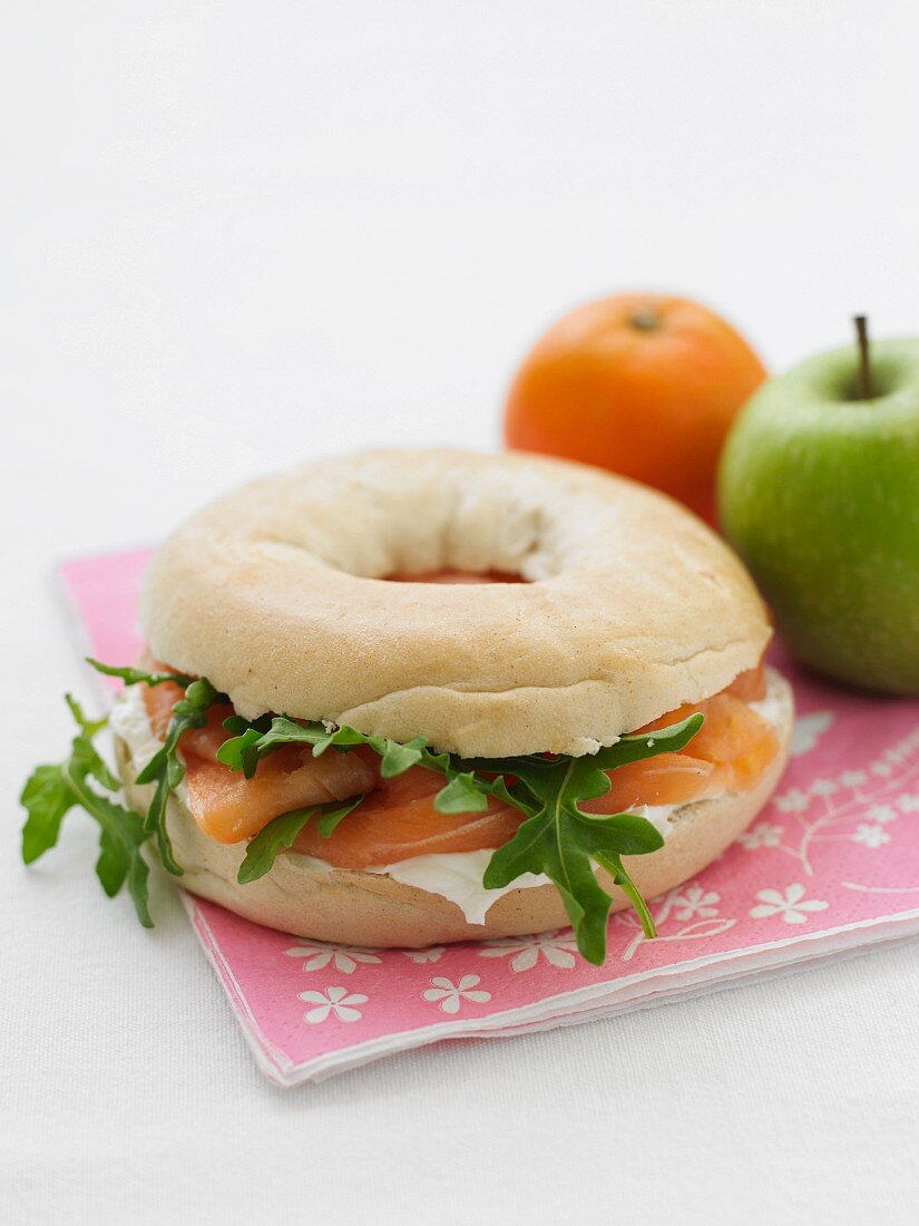 A bagel with cream cheese, salmon and rocket