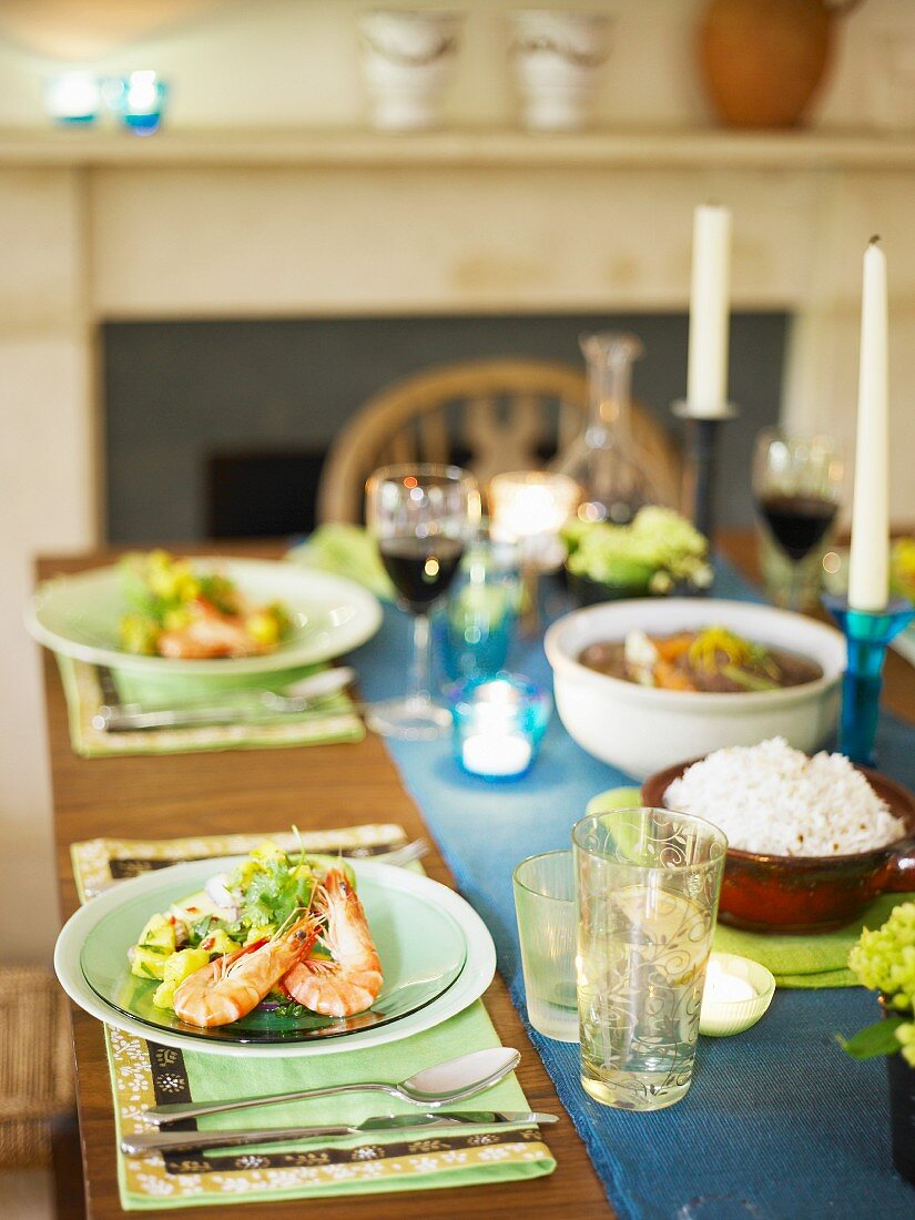 A table laden with appetisers and glasses of red wine