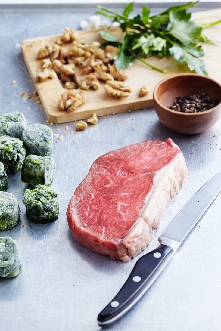 An arrangement of beef steak, frozen vegetables and nuts