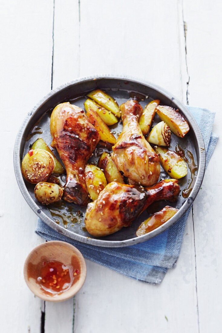 Glazed chicken legs with sesame onions and potato wedges