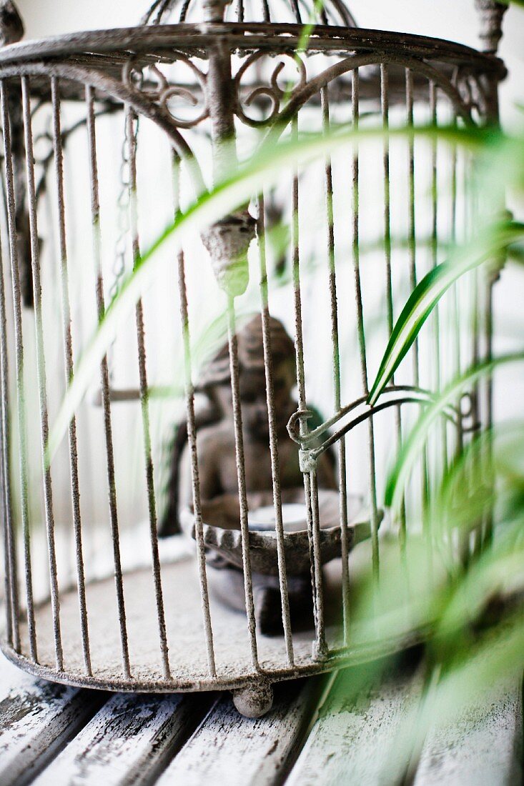 Cherub figurine in vintage, metal bird cage