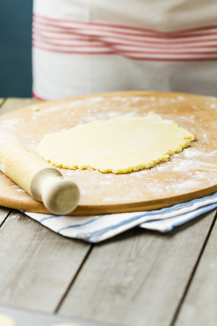 Ausgerollter Mürbteig auf bemehltem Holzbrett