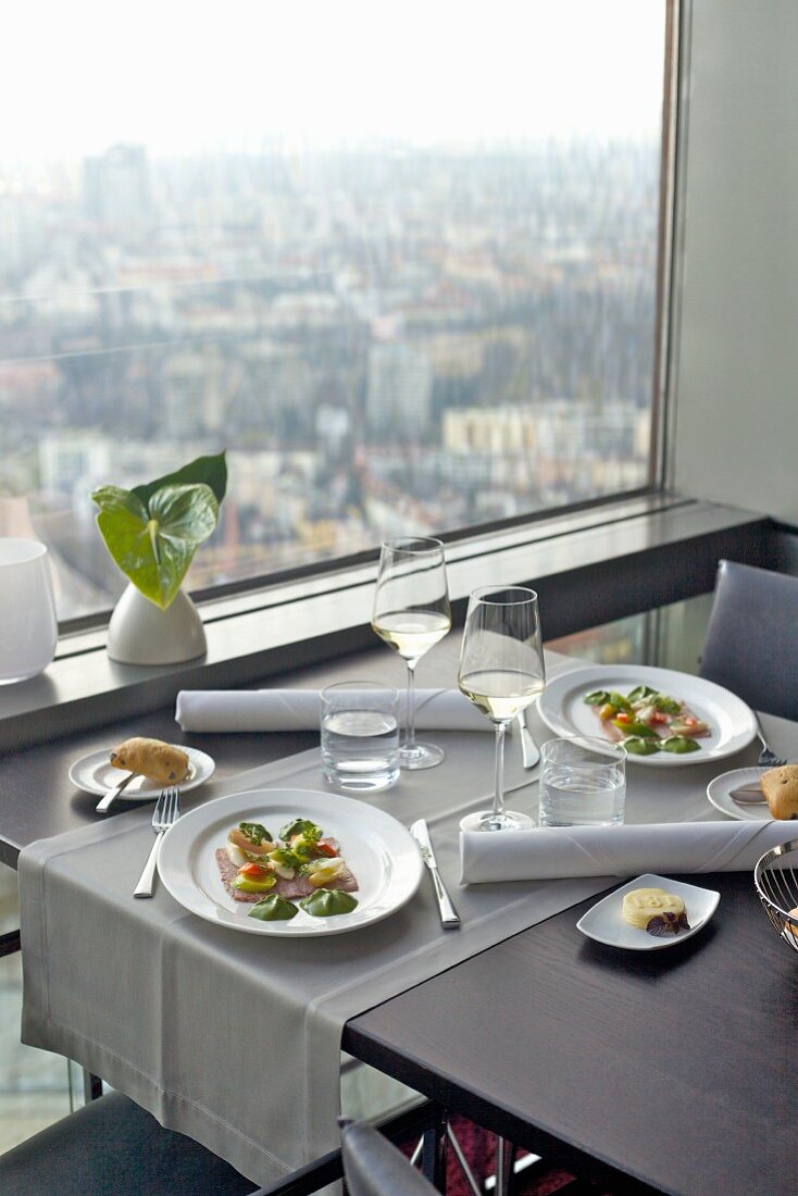 Prime boiled beef on a restaurant table in front of a large panoramic window with a view of the city