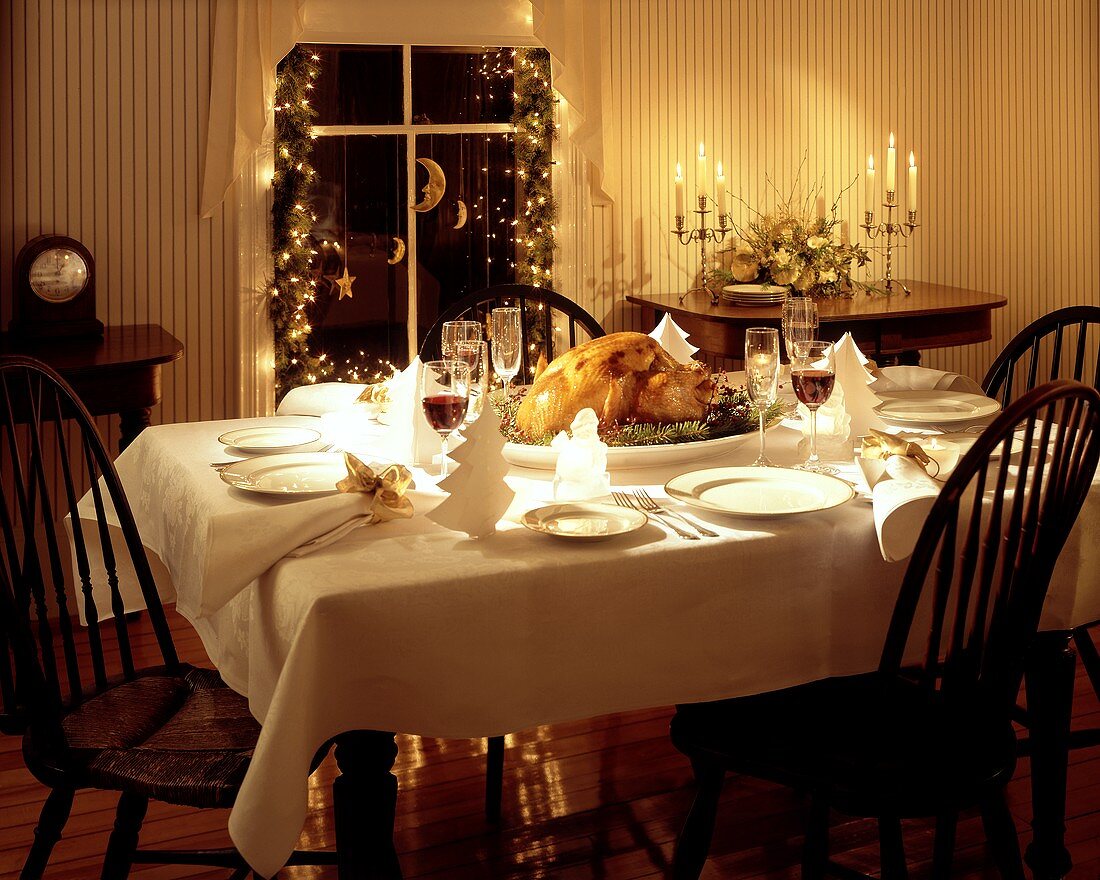 Weihnachtlich gedeckter Tisch; Truthahn mit Tannenzweigen