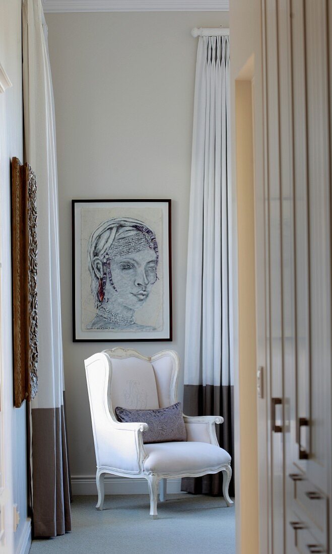 White, Rococo armchair in corner below portrait on wall