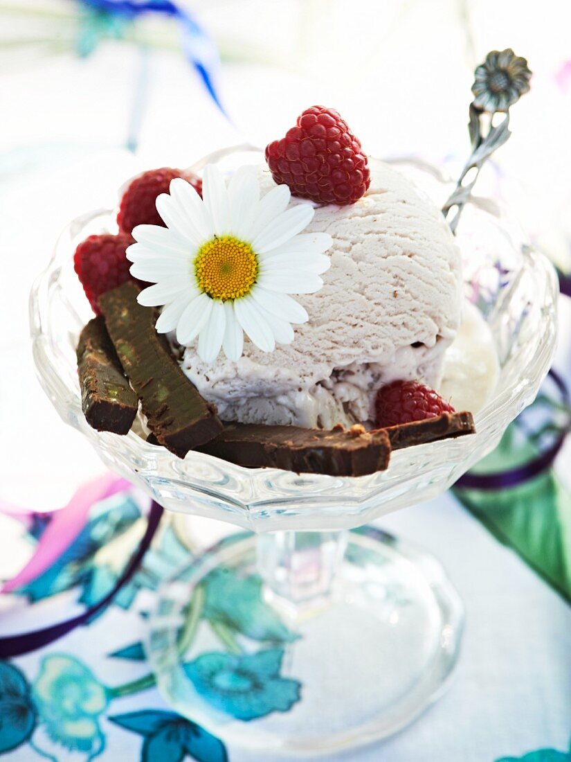 Vanilla ice cream with raspberry, chocolate and a daisy