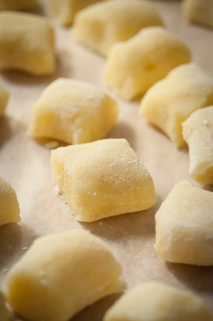 Freshly made, uncooked potato gnocchi on baking paper