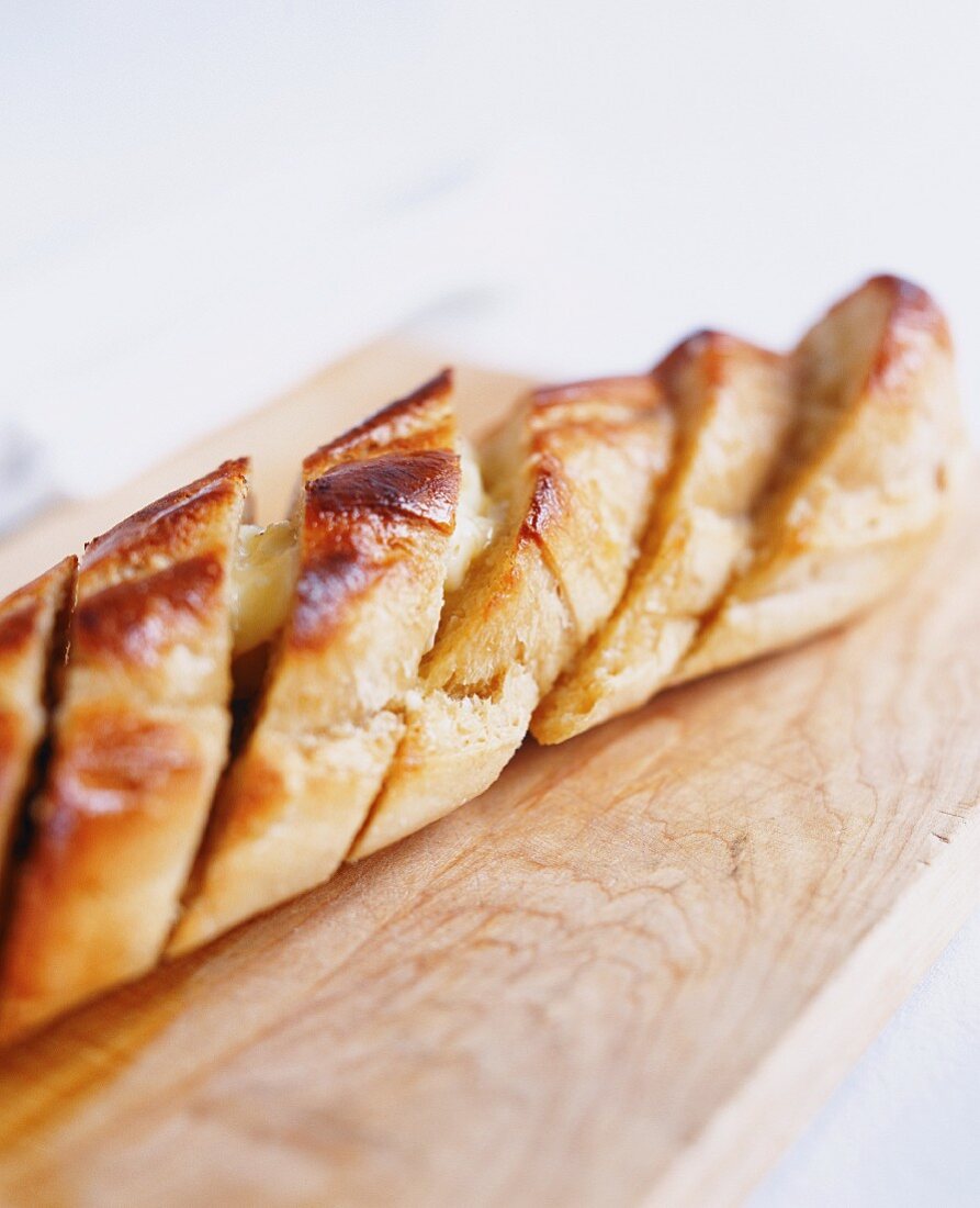 Garlic Bread Sliced on a Wooden Cutting Board; From Above; Ingredients for Garlic Bread