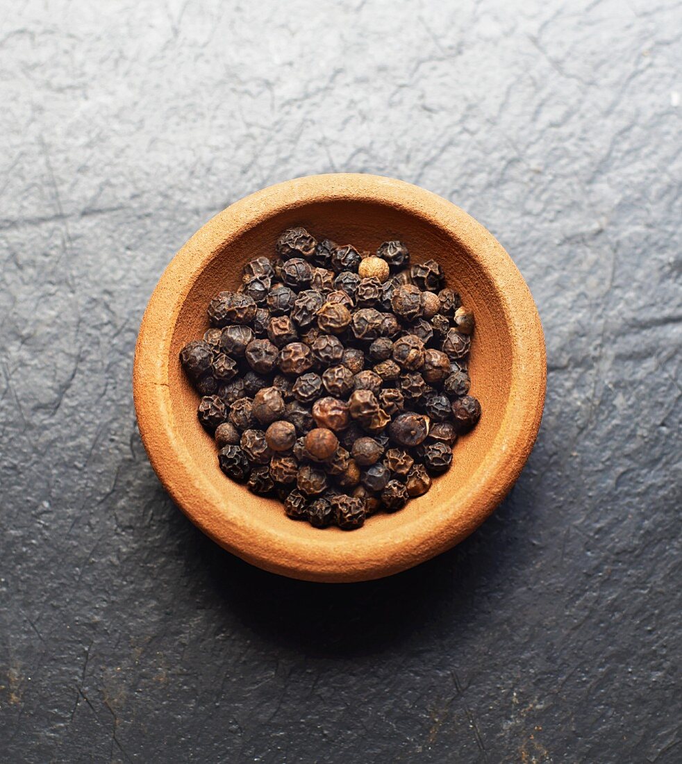 A bowl of black peppercorns
