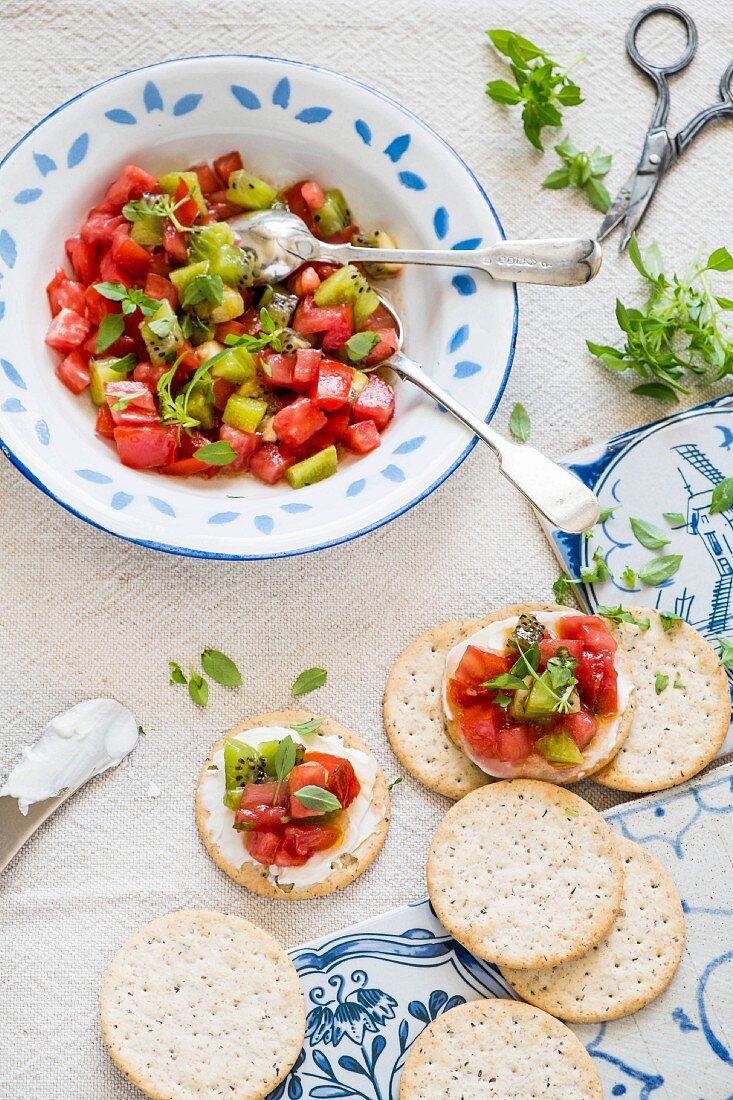 Tomaten-Kiwi-Salsa mit griechischem Basilikum auf Crackern