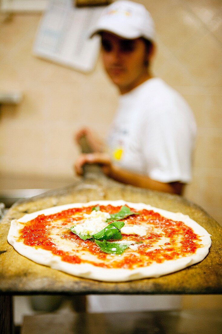 Ungebackene Pizza auf einer Pizzaschaufel