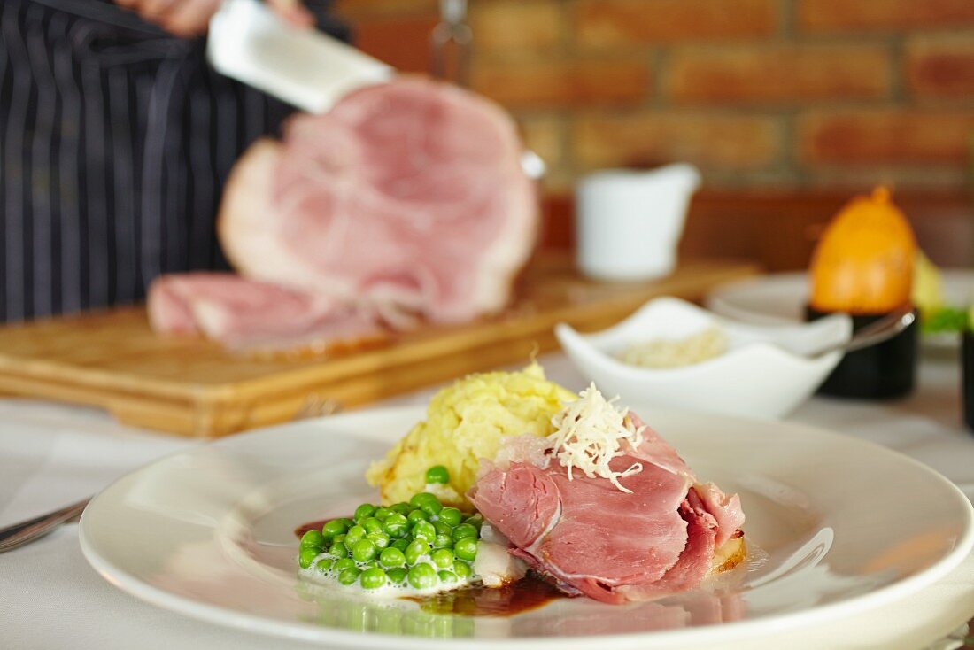 Glazed leg of ham with mashed potatoes and mint peas