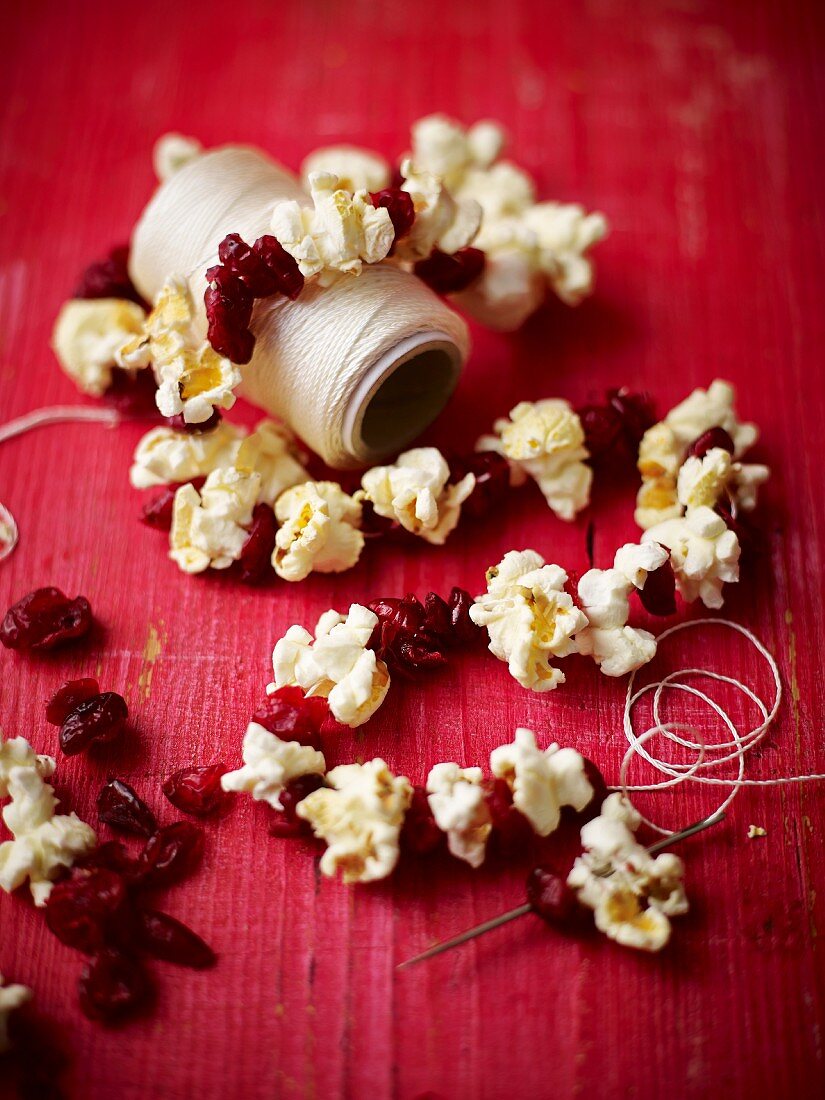 Popcorn and dried cranberries threaded onto string as Christmas decorations