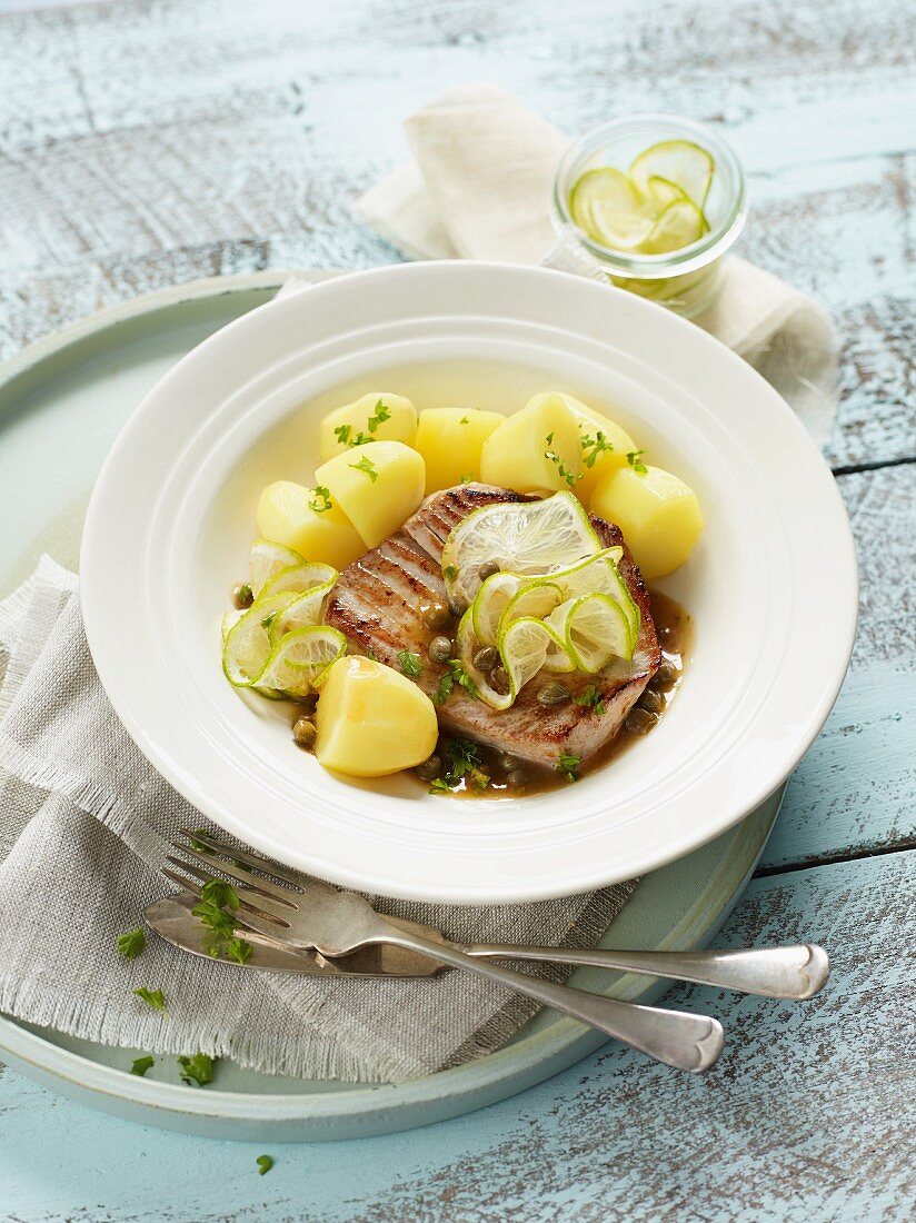Tuna fish steaks in a caper sauce with salted potatoes