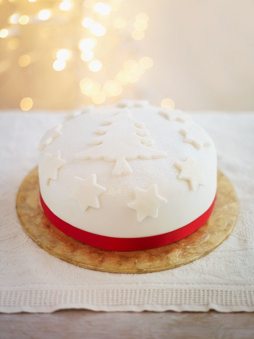 A festive Christmas cake decorated with a red satin ribbon