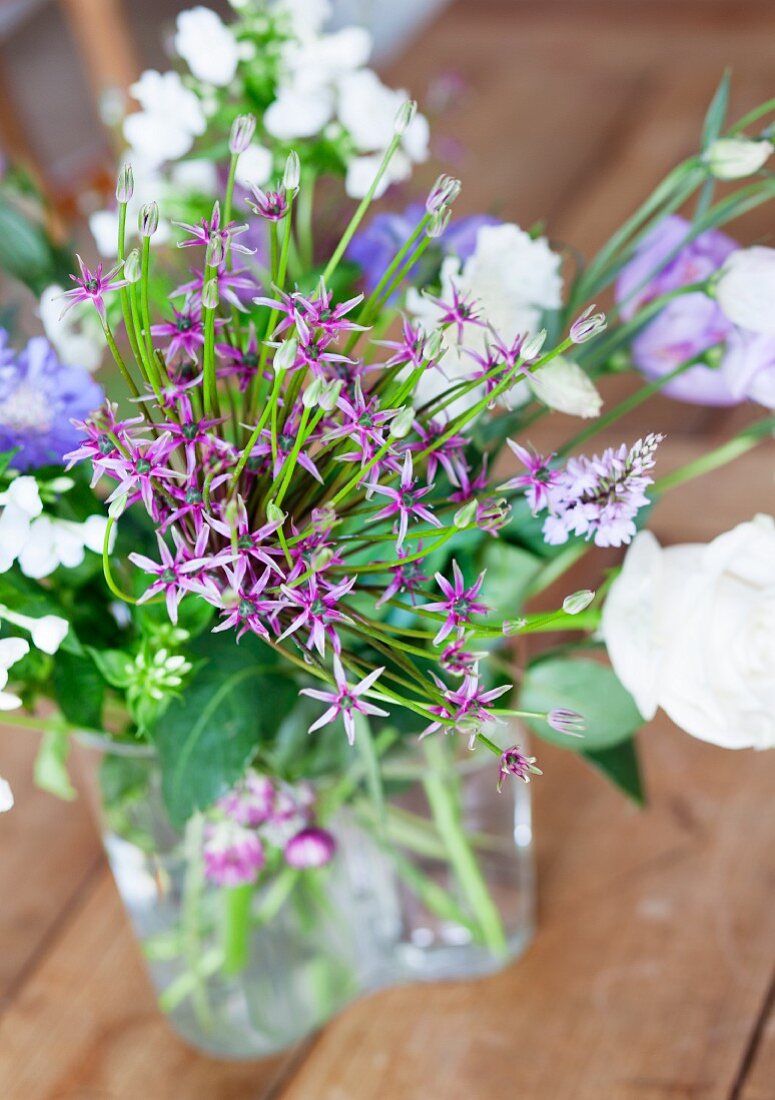 Gartenstrauss aus weissen & violetten Gartenblumen in Glasvase