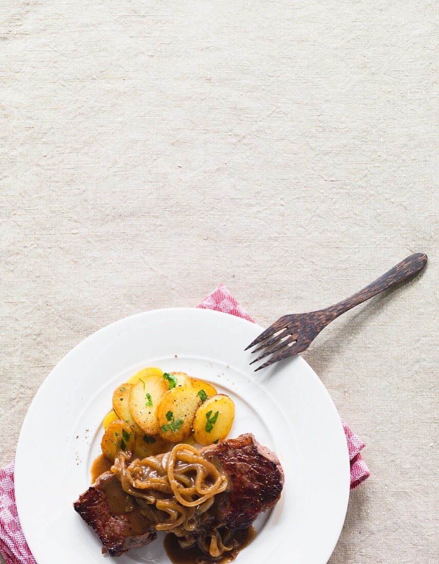Roast beef with onions served with fried potatoes