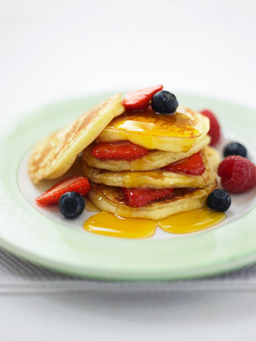 Pancakes with summer berries and maple syrup