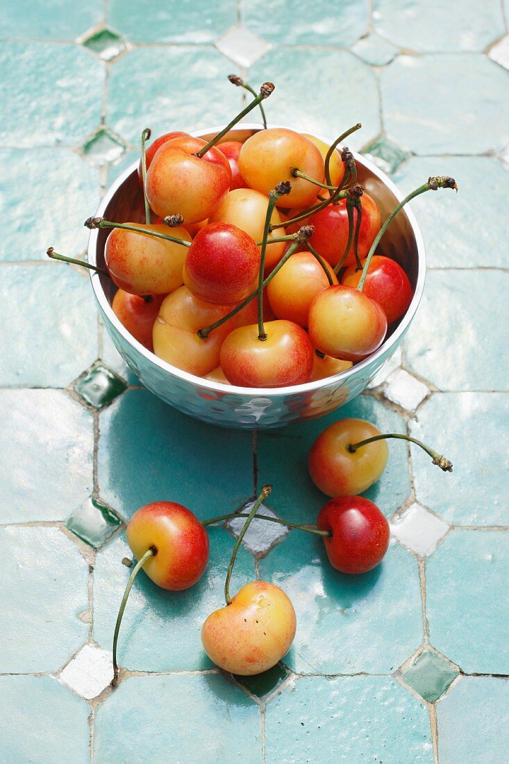 Yellow cherries in a metal bowl and next to it