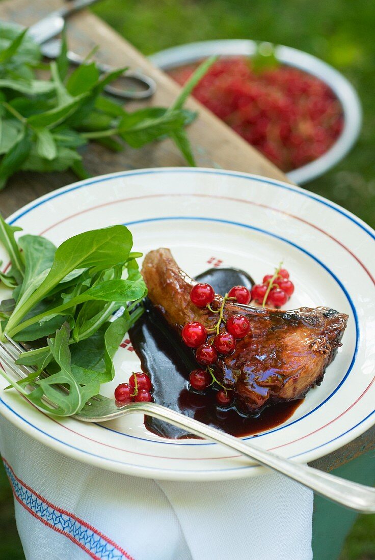 Lamb chop with redcurrant sauce on a garden table