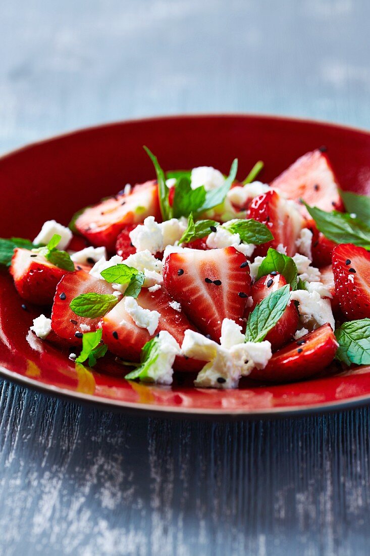 Strawberry salad with goat's cheese, fresh mint and black sesame seeds
