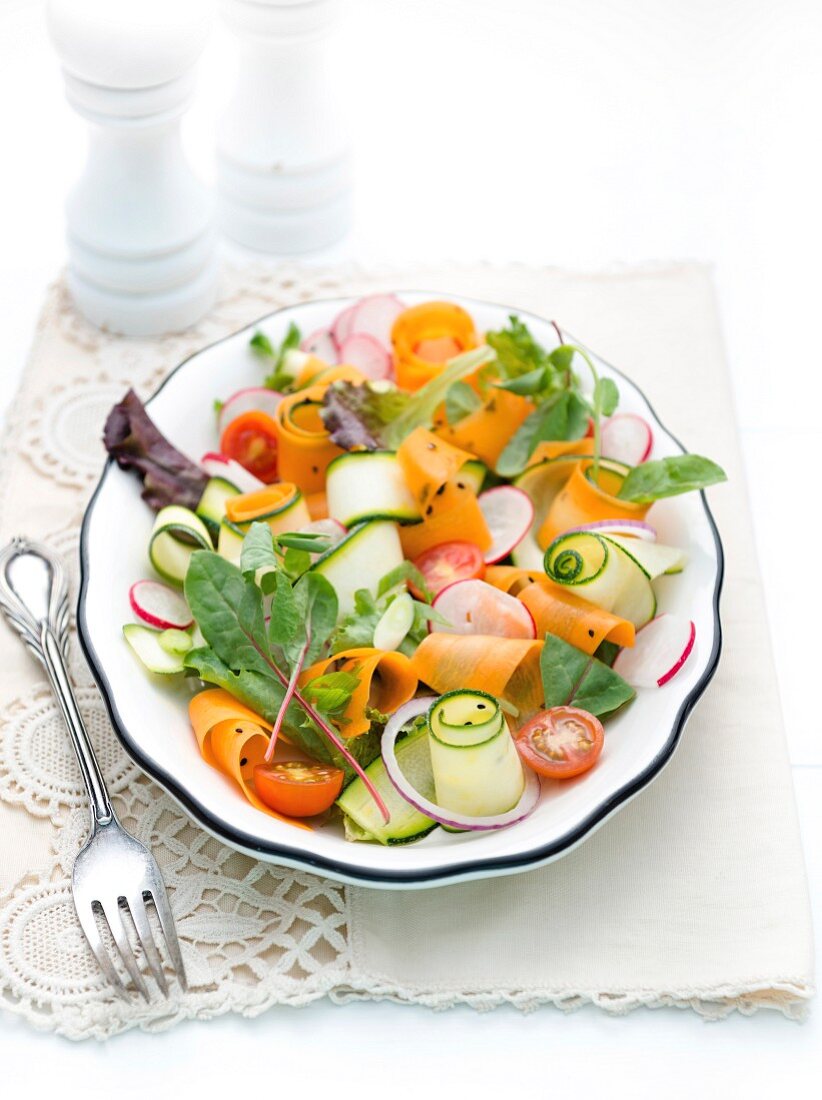 Vegetable salad with courgette strips, carrots and radishes