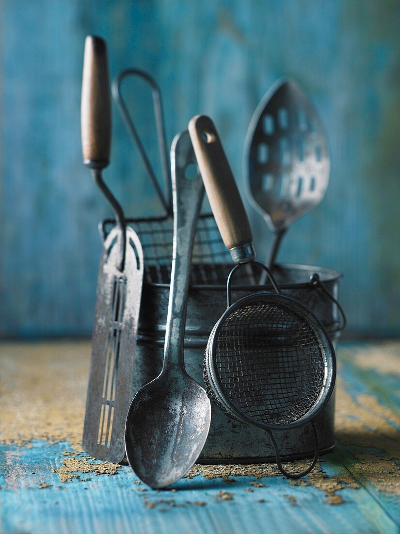 Various antique kitchen utensils on a blue wooden surface