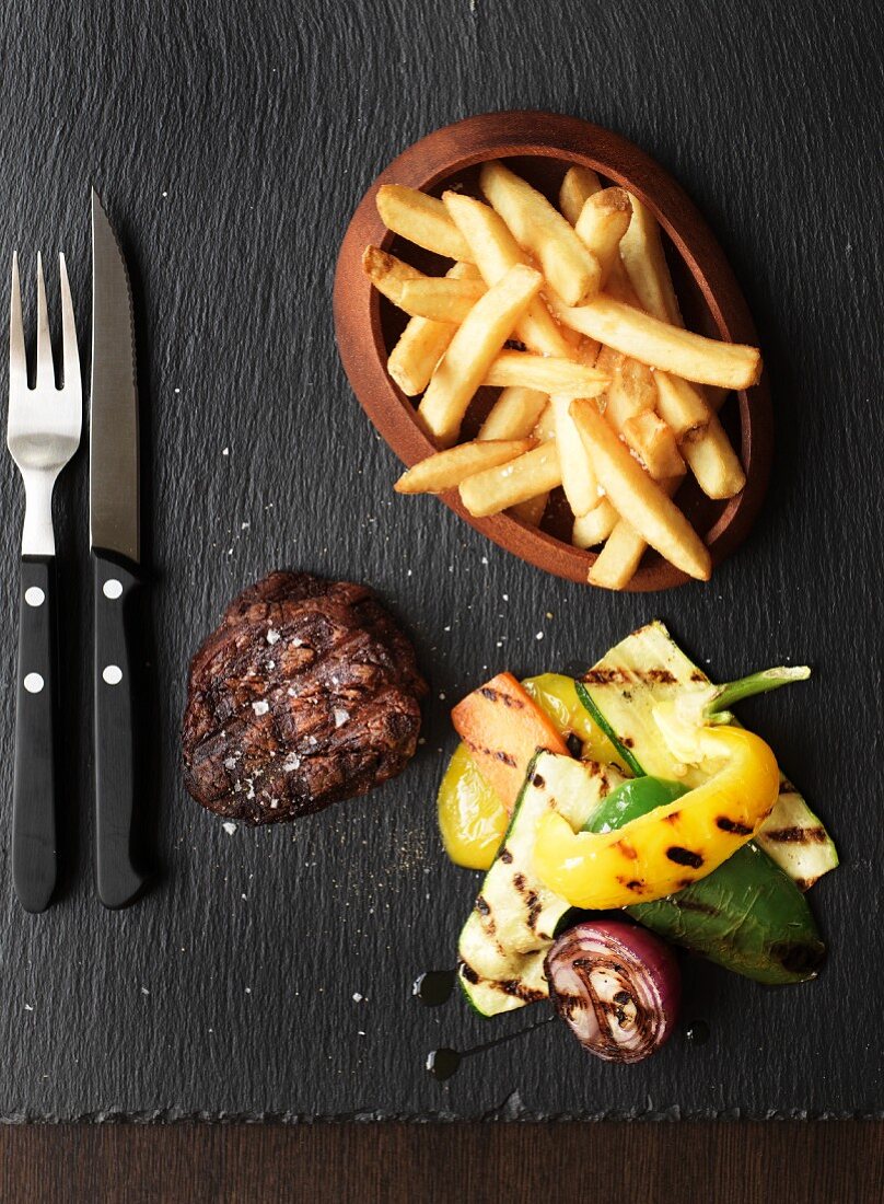 Grilled beef steak with chips and grilled vegetables