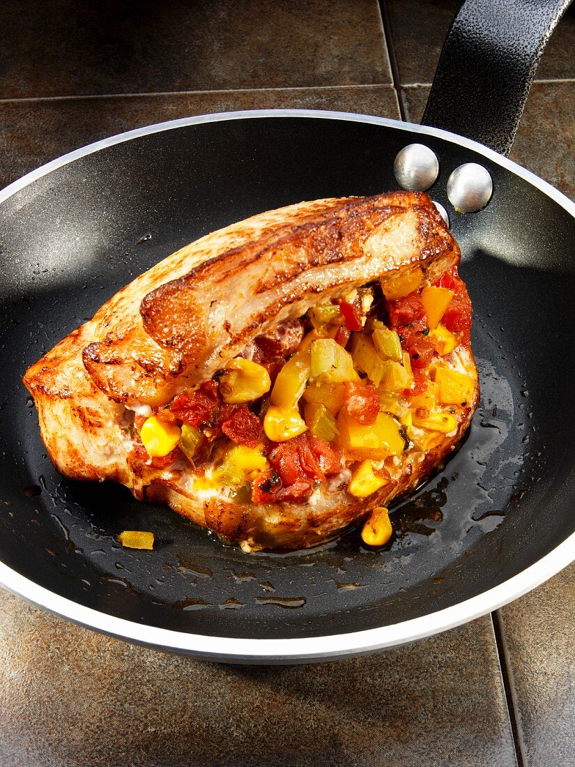A stuffed pork chop filled with sweetcorn and tomatoes