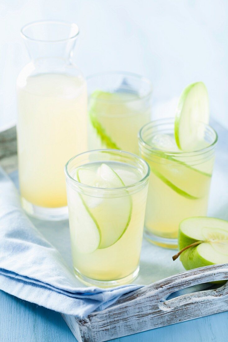 Apfel-Ingwer-Limonade in Gläsern und Karaffe