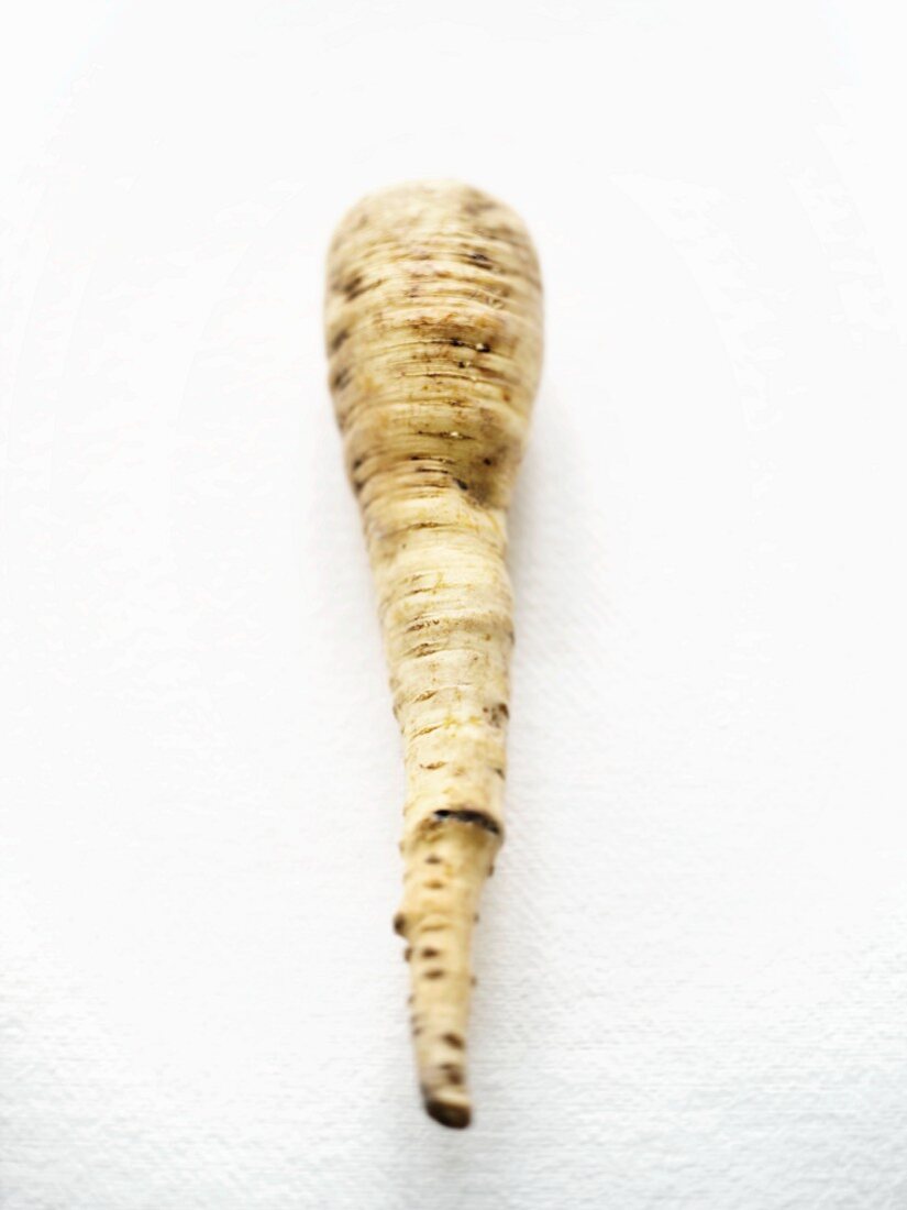 A parsnip on a white surface