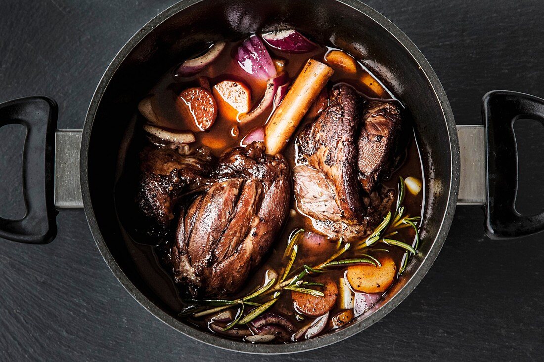Leg of lamb in red wine with onions, carrots and rosemary